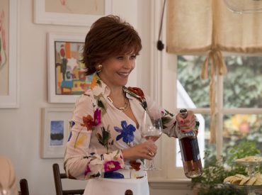 Cena do filme Do Jeito que elas querem com Jane Fonda se servindo de uma taça de vinho rosè, dentro de casa