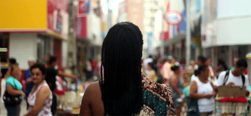 cena do documentário Mwany. Mulher negra de costas olhando para uma cidade