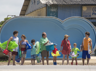 Foto divulgação filme "Benzinho". Família reunida com roupas de clube e boias.