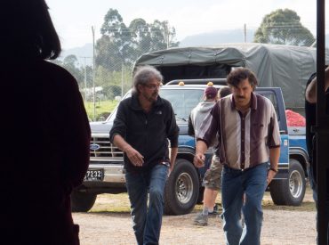Capa divulgação do filme "Escobar, a traição". Dois homens caminhando e conversando. Ao fundo camionete e caminhão e outras pessoas.