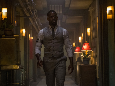 foto de divulgação do filme hotel artemis. Homem andando por um corredor de um hotel antigo