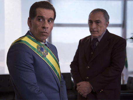 foto divulgação do filme "O Candidato Honesto". Dois homens olhando na mesma direção, sendo um com faixa de presidente da república do Brasil