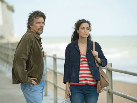 Cena do filme juliet nua e crua. Homem olhando mulher enquando ela vai embora. Estão em um pier de frente para o mar.